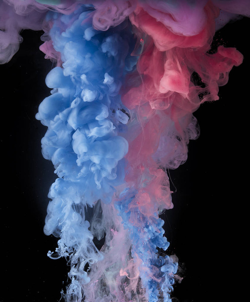 Colorful rainbow paint drops from above mixing in water. Ink swirling underwater. - Photo, Image