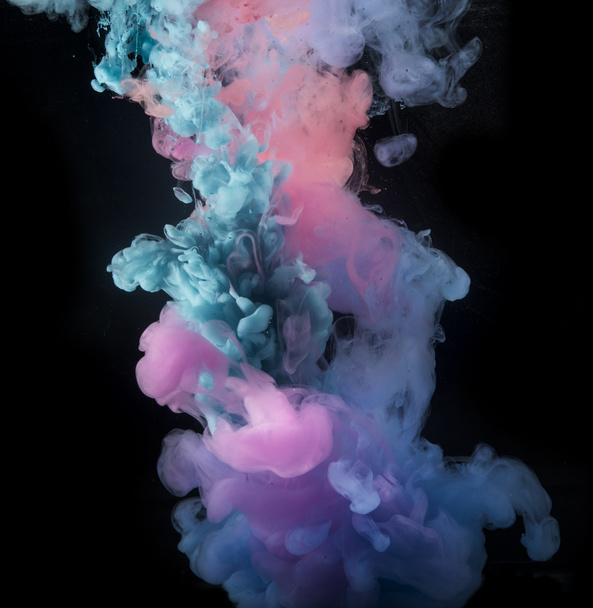 Πολύχρωμο ουράνιο τόξο σταγόνες χρώμα από πάνω ανάμειξη στο νερό. Μελάνι στροβιλίζεται κάτω από το νερό. - Φωτογραφία, εικόνα