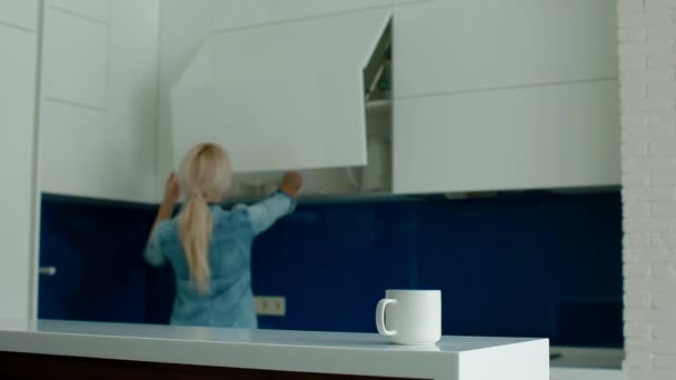 Γυναίκα πίνοντας τον καφέ στην σύγχρονη κουζίνα (Λευκός Φρέσκος) - Πλάνα, βίντεο