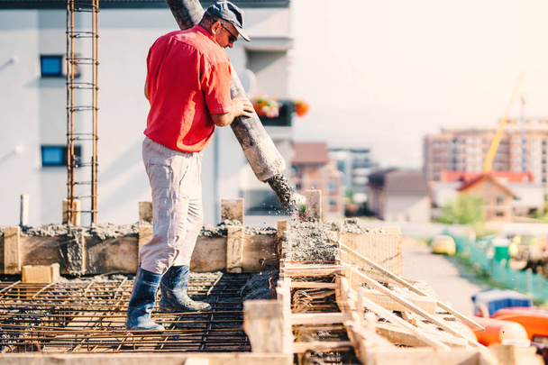 İnşaat işçisi inşaat alanına beton döküyor, inşaat detayları, endüstri - Fotoğraf, Görsel