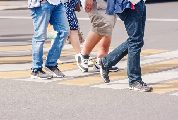 legs of pedestrians in a crosswalk on sunny summer day - Fotoğraf, Görsel