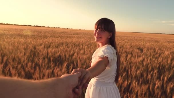 Śmiejąca się dziewczyna biegnie po polu z pszenicy gospodarstwa mans rękę w blasku słońca złote. Zwolnionym tempie. - Materiał filmowy, wideo
