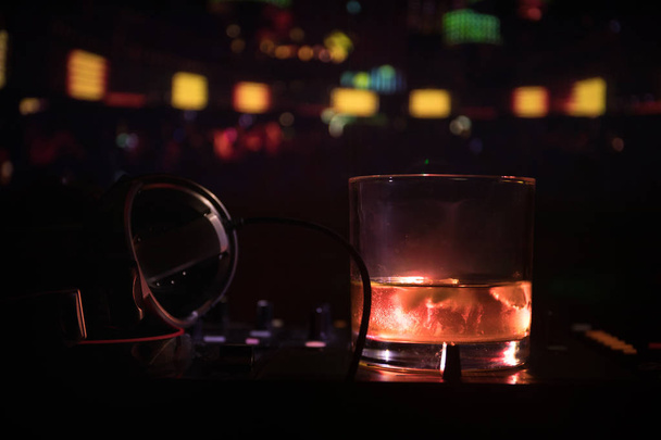 ナイトクラブで dj コント ローラー内部のアイス キューブでウイスキーとグラス。ディスコの照明とナイトクラブで音楽パーティーで飲みクラブ dj コンソール。選択と集中 - 写真・画像