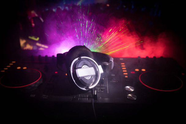 В центре внимания Pro dj control.DJ-консоль deejay mixing desk на музыкальной вечеринке в ночном клубе с разноцветными дискотечными огнями. Закрыть вид
 - Фото, изображение