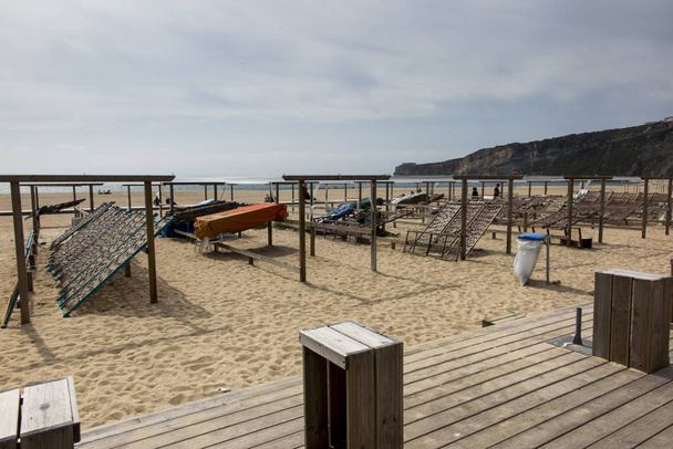 Kurutmak ve balık ve deniz ürünleri bir saman bir hasır içinde Nazare, Portekiz arka plan olarak plajda satış - Fotoğraf, Görsel