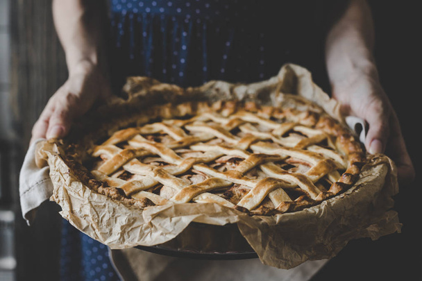 Hands holding homemade delicious apple pie. Close up - Foto, Imagem
