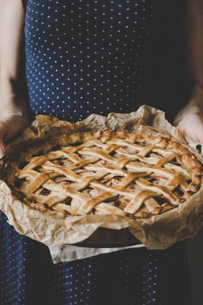 Hands holding homemade delicious apple pie. Close up - Foto, Imagen