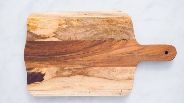 Tabla de cortar de madera rústica en mostrador de cocina de mármol
. - Foto, Imagen