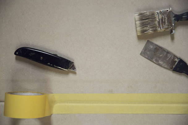Utensili per dipingere per tavole di legno. Spazzola, nastro da colorare e coltello da costruzione
 - Foto, immagini