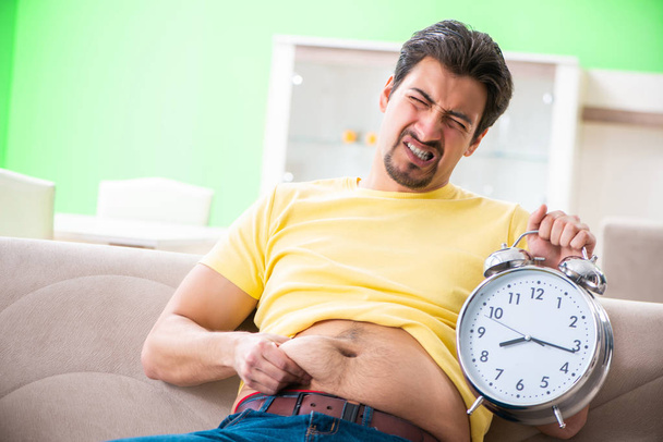 Άνθρωπος που υποφέρει από επιπλέον κιλά στην έννοια της διαχείρισης του χρόνου  - Φωτογραφία, εικόνα
