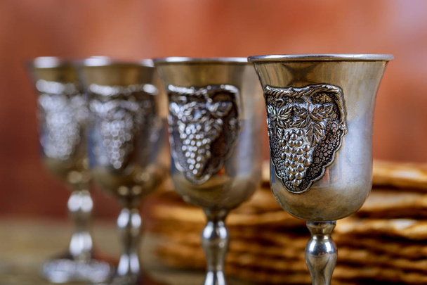 ワインは赤の清浄な 4 つのグラス、マッツァ ビンテージ ウッドの背景に過越祭 Haggadah の - 写真・画像