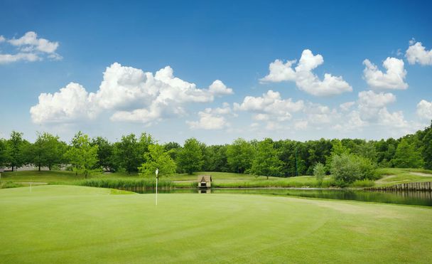 Trimmed field and sand bunkers for game on golf course, nobody. Green meadow in golfing club, playground in sunny day - Photo, image