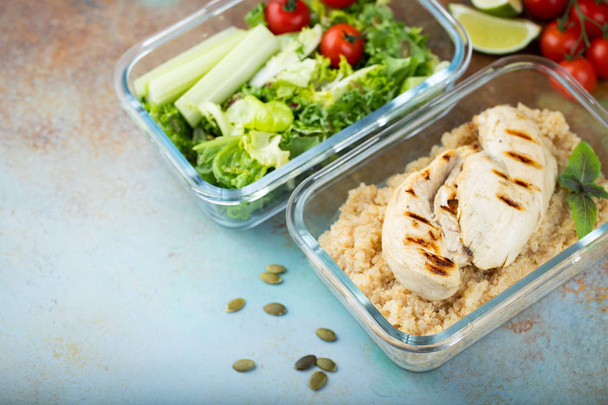 Gefäße für gesunde Mahlzeiten mit Quinoa, Hühnerbrust und grünem Salat über Kopf mit Kopierraum. - Foto, Bild
