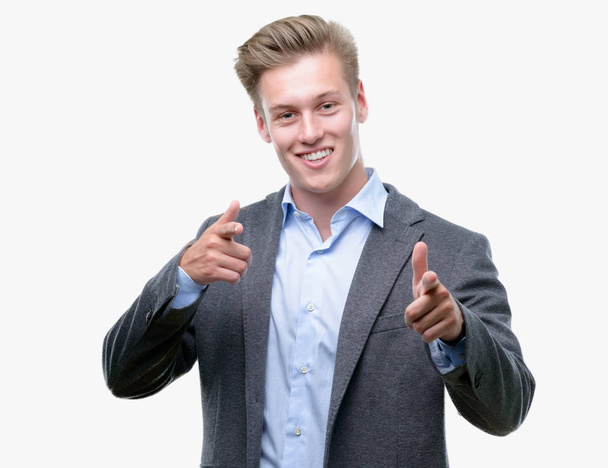 Young handsome blond business man pointing fingers to camera with happy and funny face. Good energy and vibes. - Фото, изображение
