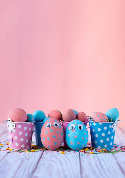 Easter background with blue and pink dotted and funny eggs. Happy easter greeting card with copy space - Fotó, kép