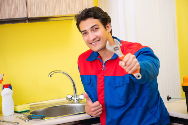Plumber repairing tap at kitchen - Photo, Image