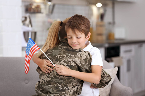 Woman in military uniform with her little son at home - Photo, Image