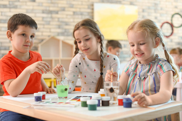 Cute little children painting at table indoors. Learning by playing - Fotoğraf, Görsel