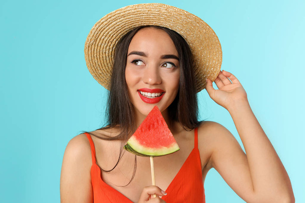 Beautiful young woman posing with watermelon on color background - Фото, зображення