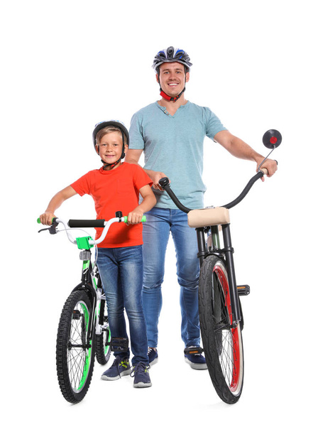 Portret van vader en zoon met fietsen op witte achtergrond - Foto, afbeelding