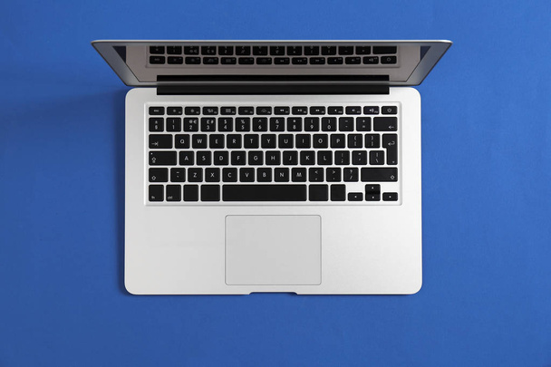 Modern laptop on color background, top view - Fotó, kép