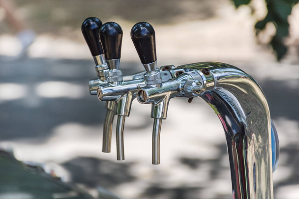 Chrome beer tap in park on jazz music festival. Alcohol beverage concept. Close up, selective focus - Photo, Image