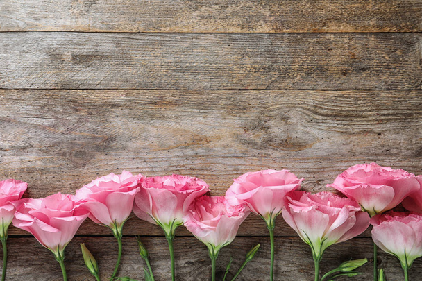 Flat lay composition with beautiful Eustoma flowers on wooden background - Foto, immagini