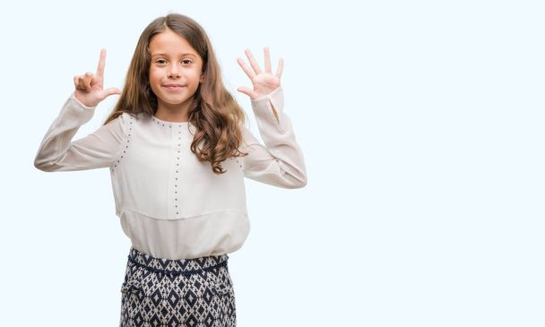 Morena hispânica menina mostrando e apontando para cima com os dedos número sete, sorrindo confiante e feliz
. - Foto, Imagem