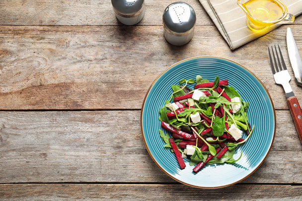 Plate with delicious beet salad on wooden table, top view - Foto, Bild