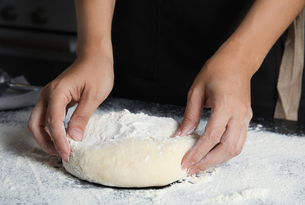 Woman making dough for pastry on table - Fotó, kép