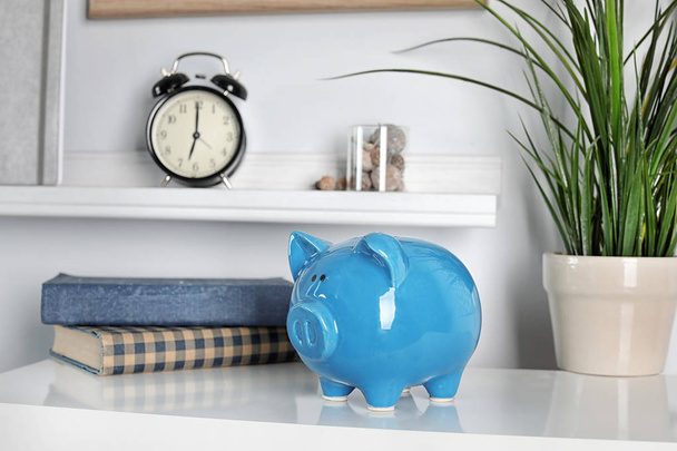 Cute piggy bank on table indoors. Stylish interior - Фото, зображення