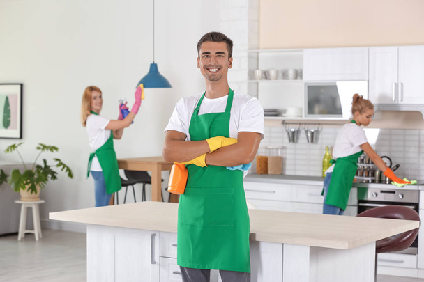Équipe de concierges professionnels dans la cuisine de nettoyage uniforme
 - Photo, image