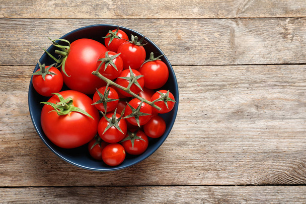Bowl with tasty juicy tomatoes and space for text on wooden background, top view - Foto, Imagem