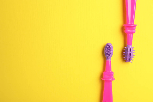 Manual toothbrushes for children on color background, top view with space for text - 写真・画像