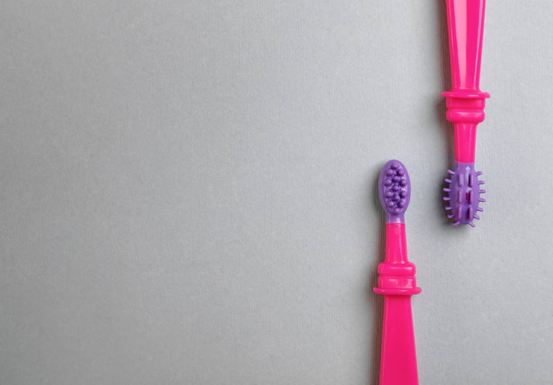 Ручные зубные щетки для детей на сером фоне, вид сверху с пространством для текста
 - Фото, изображение