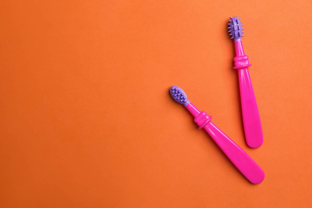 Cepillos de dientes manuales para niños sobre fondo de color, vista superior con espacio para texto
 - Foto, imagen