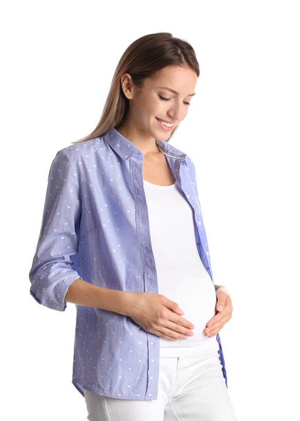 Happy pregnant woman touching her belly on white background - Zdjęcie, obraz
