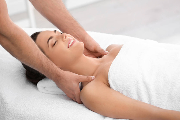 Relaxed woman receiving shoulders massage in wellness center - Fotó, kép