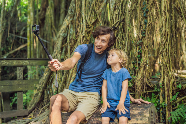Dad and son travelers discovering Ubud forest in Monkey forest, Bali Indonesia. Traveling with children concept. - Foto, Bild