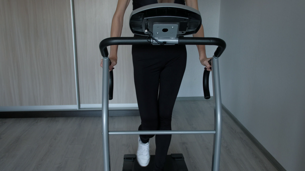Attractive woman running at home on a treadmill - Footage, Video