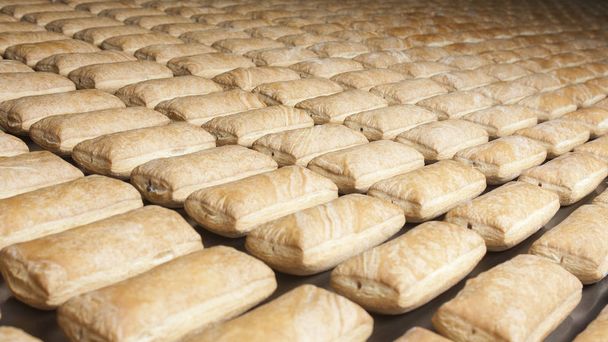 Grupo de pasteles horneados en la línea de producción
 - Foto, Imagen