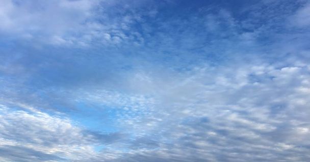 Prachtige wolken tegen de achtergrond van een blauwe hemel. Wolk lucht. Blauwe hemel met bewolkt weer, natuur wolk. Witte wolken, blauwe lucht en zon. - Foto, afbeelding