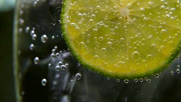 Concept de désintoxication ou soif. Alimentation saine et diététique. Citronnade froide, boisson au citron vert. Fond noir
 - Séquence, vidéo