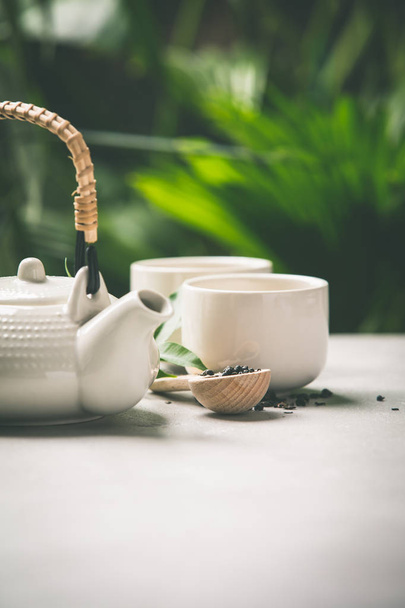 Tea composition on tropical leaves background - Фото, изображение