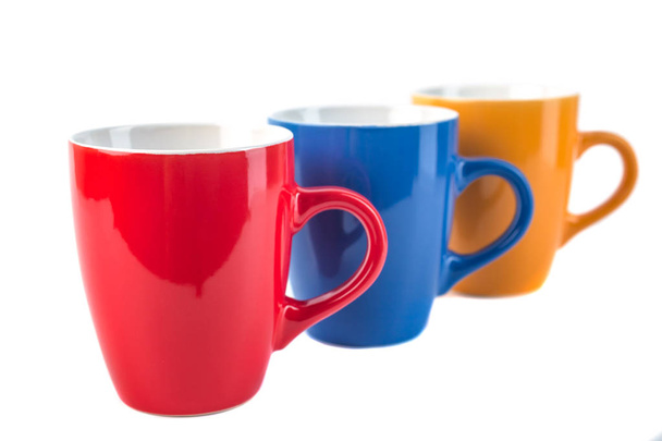 Three color ceramic cups on a white background. - Photo, Image