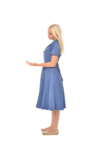 ritratto a figura intera di ragazza bionda che indossa un vestito blu, in piedi posa. isolato su sfondo bianco dello studio
. - Foto, immagini