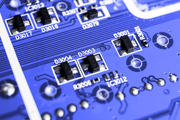 Macro shot of a Circuitboard with resistors microchips and electronic components. Computer hardware technology. Integrated communication processor in blue tones. Semiconductor. PCB. Closeup - Zdjęcie, obraz