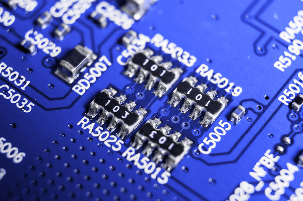 Macro shot of a Circuitboard with resistors microchips and electronic components. Computer hardware technology. Integrated communication processor in blue tones. Semiconductor. PCB. Closeup - Foto, Imagem