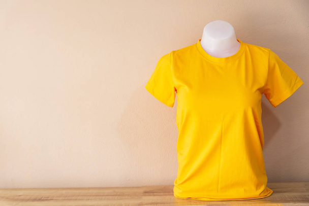 T-shirt jaune isolé sur un fond de couleur pastel
 - Photo, image