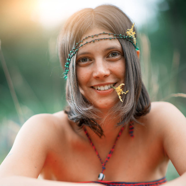 Retrato de una chica de estilo hippie Woodstock. Con flor en la boca. fotografía deliberadamente vintage
 - Foto, Imagen